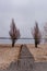 Wooden pathway on sand leading to waterfront river