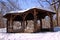 The wooden pavilion covered with the winter snow