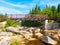 Wooden pedestrian bridge over river Jizera full of granite boulders. Czech-Polish border between Jizerka and Orle