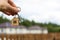 Wooden pendant of a house and key. Background of fence and cottage. Dream of home, building, design, delivery of the project, movi