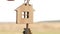 Wooden pendant of a house and key in hand. Background of the sky and field. Dream of home, building a cottage in the countryside,