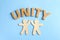 Wooden people giving high five and word UNITY