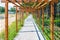 Wooden pergola (treillage) above cobblestone sidewalk leading along lake shoe and forest.