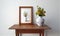 Wooden photo frame next to a vase with flowers on a wooden table on a white background, generative AI