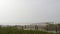 Wooden picket fence, sandy misty beach, California USA. Pacific ocean coast, fog haze on sea shore.