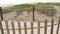 Wooden picket fence, sandy misty beach, California USA. Pacific ocean coast, fog haze on sea shore.