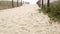 Wooden picket fence, sandy misty beach, California USA. Pacific ocean coast, fog haze on sea shore.