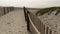 Wooden picket fence, sandy misty beach, California USA. Pacific ocean coast, fog haze on sea shore.