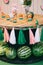 Wooden picnic table children`s holiday birthday with watermelons, decor of white and pink ribbons and painted by banks