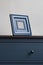 Wooden picture frame on blue chest of drawers