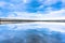 Wooden pier, clouds and stormy sky reflected in calm waters of North Sea - seaside landscape of Northumberland