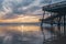 Wooden pier, a famous touristic attraction, wide sandy beach, Pacific ocean, and beautiful cloudy sky. Pismo Beach, California