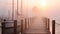 Wooden pier in a foggy morning at sunrise with sailing boats, AI Generated