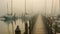 Wooden pier in a foggy morning. Yachts and boats in the background, AI Generated