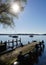 wooden pier on island Frauenchiemsee or Fraueninsel on lake Chiemsee with Alps in the background in Bavaria on a sunny day in May