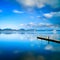 Wooden pier or jetty and on a blue lake sunset and sky reflection on water. Versilia Tuscany, Italy