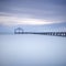 Wooden pier or jetty silhouette and blue ocean on sunset