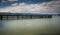 Wooden pier on lake Zurich with rolling hills mountain landscape and sailboats in the background