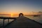 Wooden pier leading hut on indian ocean in the Maldives at sunset