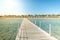 Wooden pier leading to the shore on a sunny day/beautiful wooden pier at the sea leading to the shore with blue sky