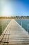 Wooden pier leading to the shore on a sunny day/beautiful wooden pier at the sea leading to the shore with blue sky