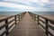 Wooden pier leads straight over the beach and the sea to the horizon, concept for the way forward into an uncertain future, copy