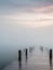 A wooden pier at misty dawn in a still sea