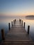 A wooden pier at misty dawn in a still sea