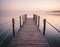 A wooden pier at misty dawn in a still sea