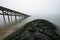 Wooden pier with the mossy stones on the foreground under a scenic cloudy sky