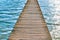 Wooden pier over water with waves on a sunny summer day