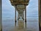 Wooden pier overlooking an expansive body of water with crashing waves.