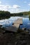 Wooden pier with the reflection of landscape and clouds in a lake in summer.