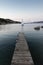Wooden pier and sailboats sailing in evening calm sea of marvellous Porto Rafael, Costa Smeralda, Sardinia, Italy