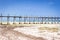 Wooden pier on sunny day. Low tide of Indian Ocean. Idyllic exotic resort. Pier in perspective. Tropical paradise.