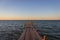 Wooden pier at the sunset. Evening sky over sea with footbridge. Calm evening landscape. Empty pier at seaside with copy scape.