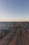 Wooden pier at the sunset. Evening sky over sea with footbridge. Calm evening landscape. Empty pier at seaside with copy scape.