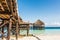 Wooden pier with thatched roof in ocean