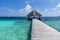 A wooden pier towards a Maldivian stilt house