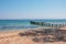 Wooden pier turquoise sea water sunny day, stones beach, greece island. Romantic wild place. Clear water sea. wooden