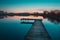 Wooden pier and a view of a calm lake after sunset