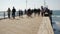 Wooden pier waterfront boardwalk, California beach USA. Defocused ocean, sea waves. People walking.