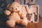 Wooden piggy bank with brown teddy bear. Money saving concept. Vintage picture style