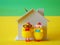 Wooden piggy bank house with coins and chickens