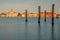 Wooden pilings on the water's surface with beautiful buildings in the background. Venice, Italy.