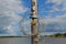 Wooden pillar with old lantern and wires against the sky