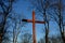 wooden plain cross in the forest among the trees. silhouettes of tribes