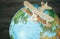 Wooden plane model is on the earth globe. Travel concept image