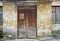 Wooden plank door with post box, dirty stucco wall background