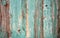 Wooden plank painted blue and brown with vertical veins deteriorated by the passage of time.